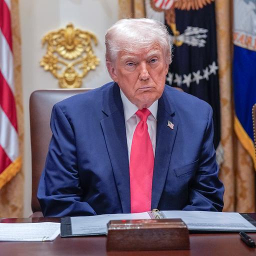 US-Präsident Donald Trump mit grimmiger Miene vor mehreren Flaggen