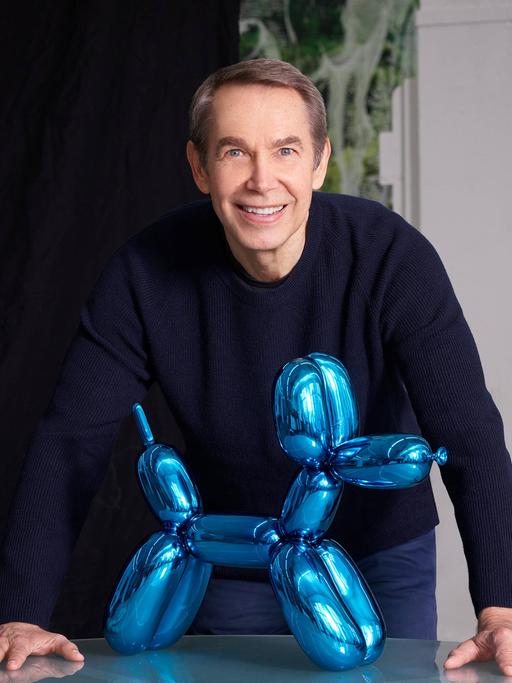Jeff Koons steht hinter einer seiner "Ballon-Hund"-Glasskulpturen Jeff Koons steht hinter einer seiner "Ballon-Hund"-Glasskulpturen
