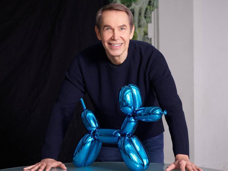 Jeff Koons steht hinter einer seiner "Ballon-Hund"-Glasskulpturen Jeff Koons steht hinter einer seiner "Ballon-Hund"-Glasskulpturen