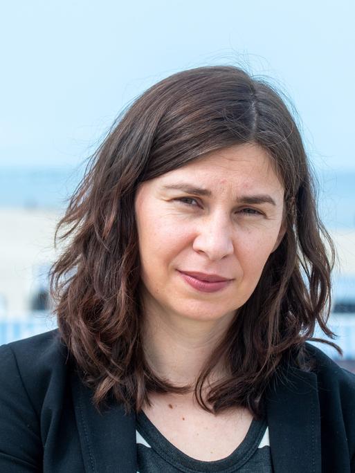 Tanja Maljartschuk steht an einem Strand auf der Ostsee-Insel Usedom und blickt ernst in die Kamera.