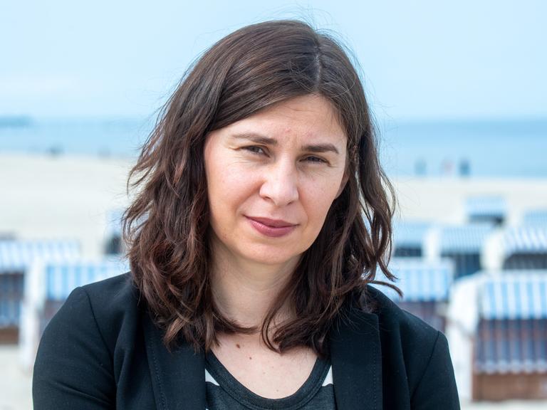 Tanja Maljartschuk steht an einem Strand auf der Ostsee-Insel Usedom und blickt ernst in die Kamera.