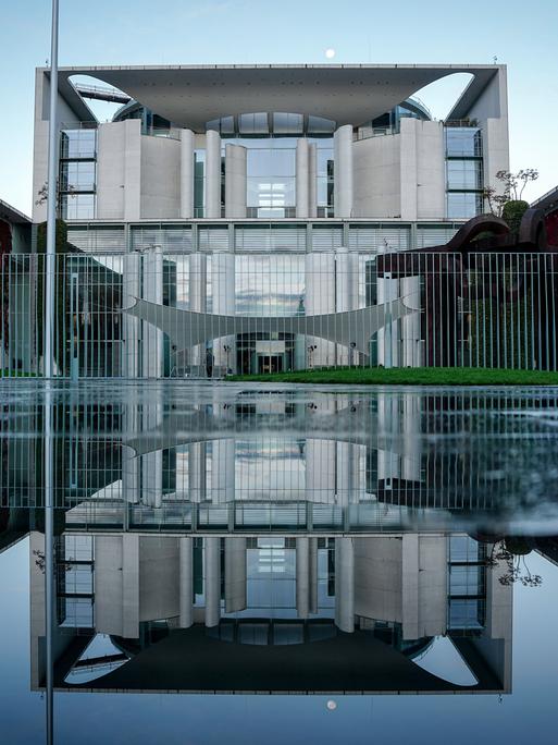 Das Bundeskanzleramt spiegelt sich am Morgen nach dem Koalitionsausschuss in einer Pfütze. 