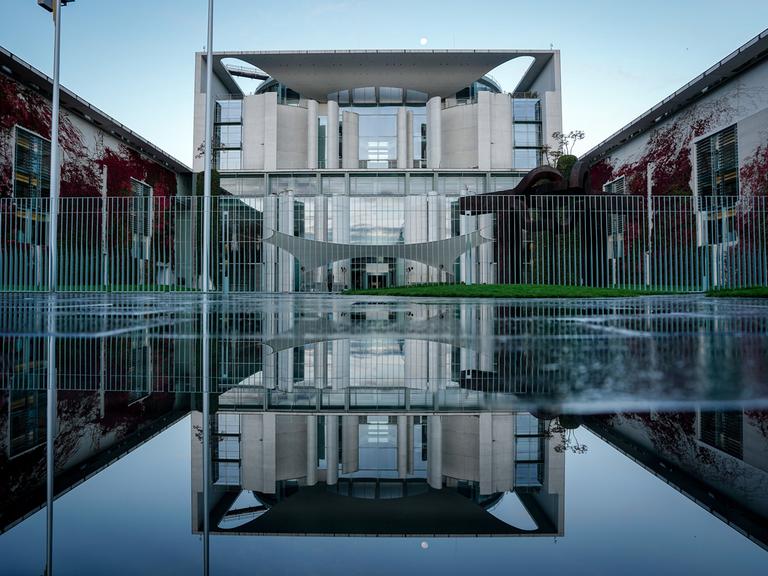 Das Bundeskanzleramt spiegelt sich am Morgen nach dem Koalitionsausschuss in einer Pfütze. 