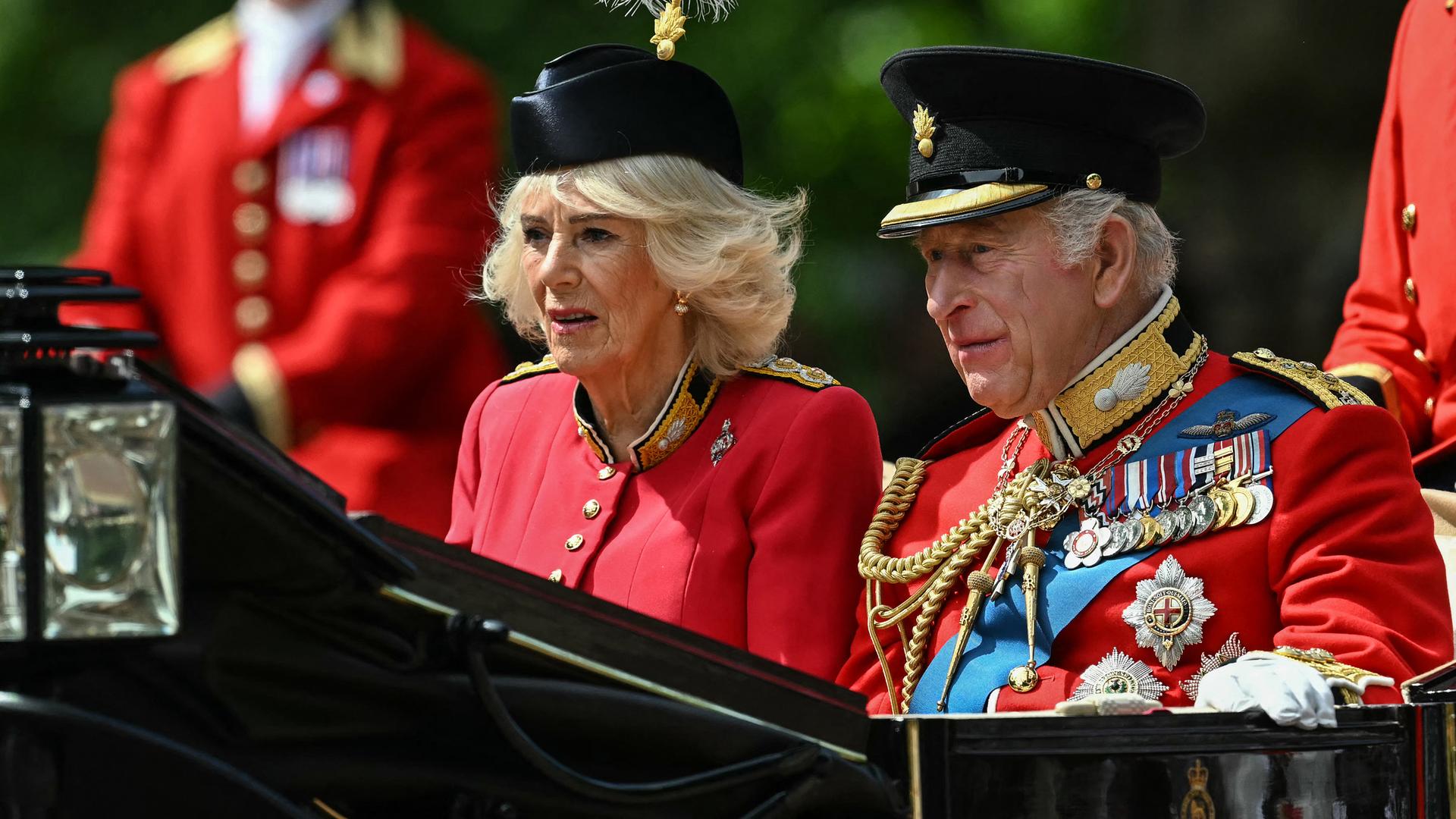 König Charles III. und Königin Camilla in einer schwarzen Kutsche