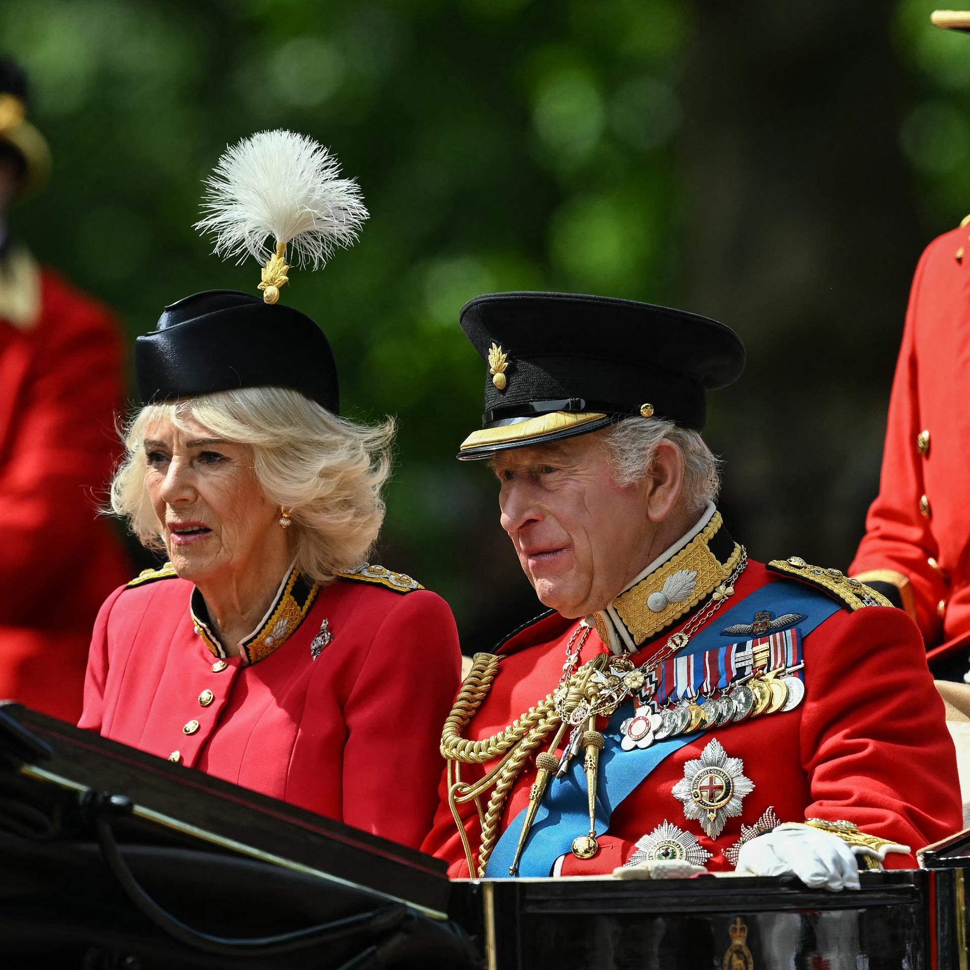 König Charles III. und Königin Camilla in einer schwarzen Kutsche