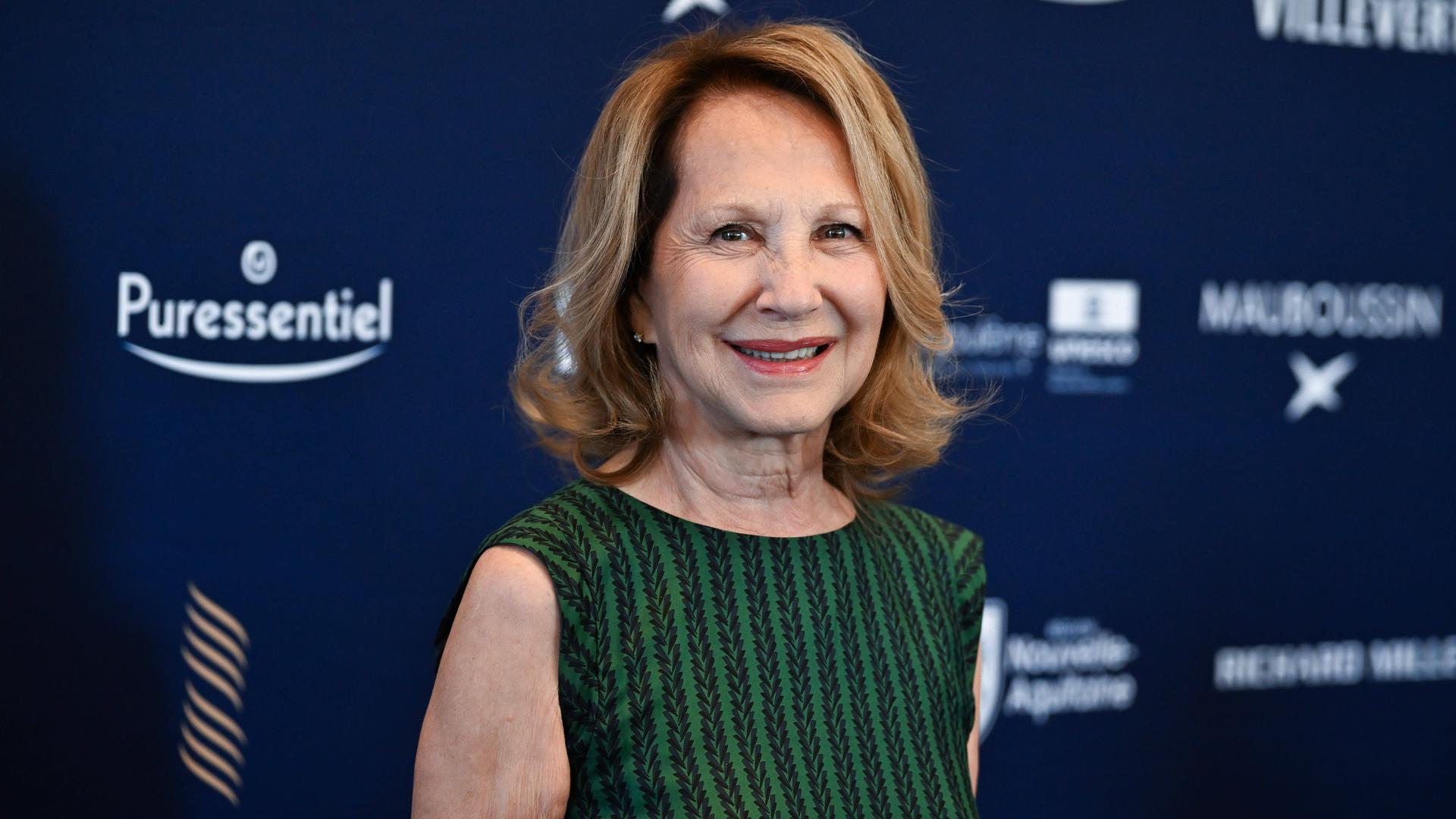 Nathalie Baye bei einem Filmfestival in Angouleme 2024; sie trägt ein grün-gestreiftes ärmelloses Top und lächelt in die Kamera.