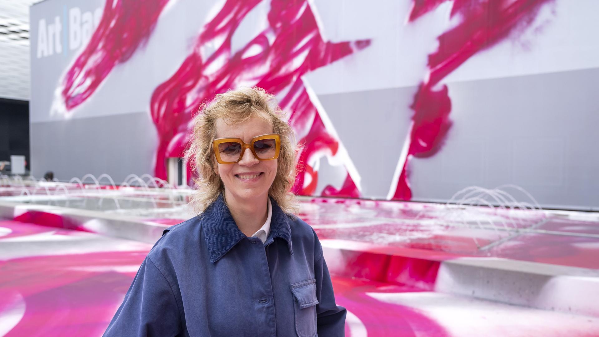 Im Rahmen des Messeplatz-Projekts auf der Art Basel 2025 posiert die deutsche Künstlerin Katharina Grosse neben ihrem Kunstwerk "CHOIR (2025)". Im Rahmen des Messeplatz-Projekts auf der Art Basel 2025 posiert die deutsche Künstlerin Katharina Grosse neben ihrem Kunstwerk "CHOIR (2025)".