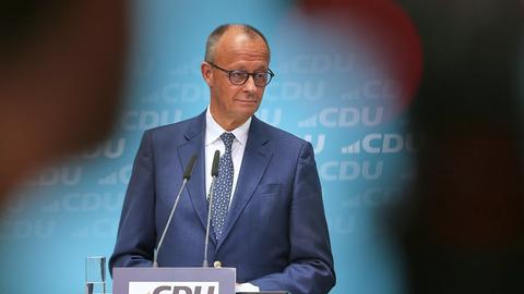 CDU-Chef und Bundeskanzler Friedrich Merz steht an einem Rednerpult und schaut zur Seite