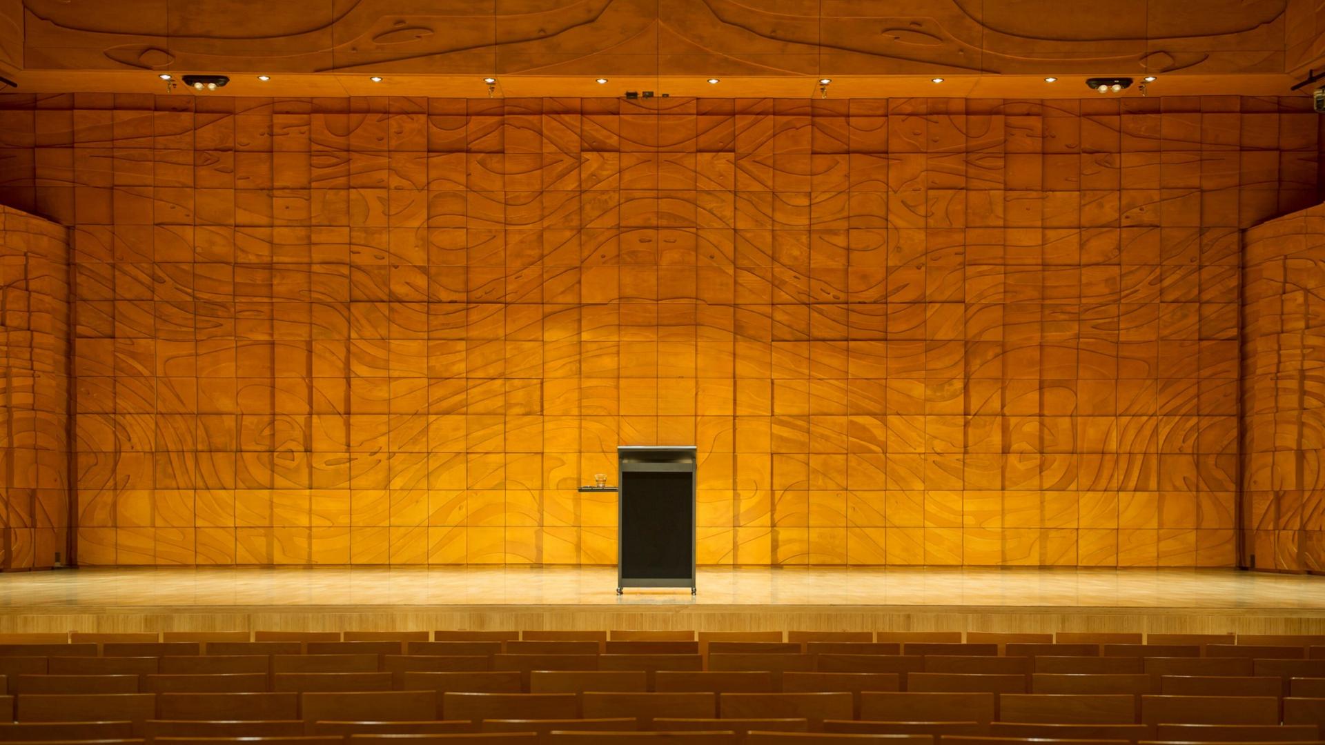 Ein leeres Pult auf einer leeren Bühne in einem leeren Auditorium.