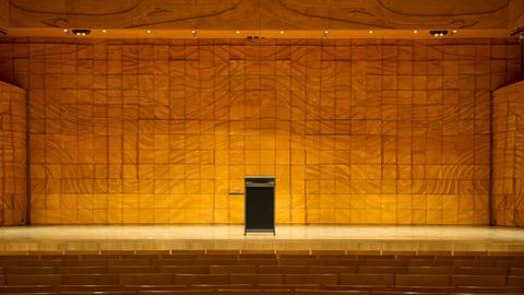 Ein leeres Pult auf einer leeren Bühne in einem leeren Auditorium.