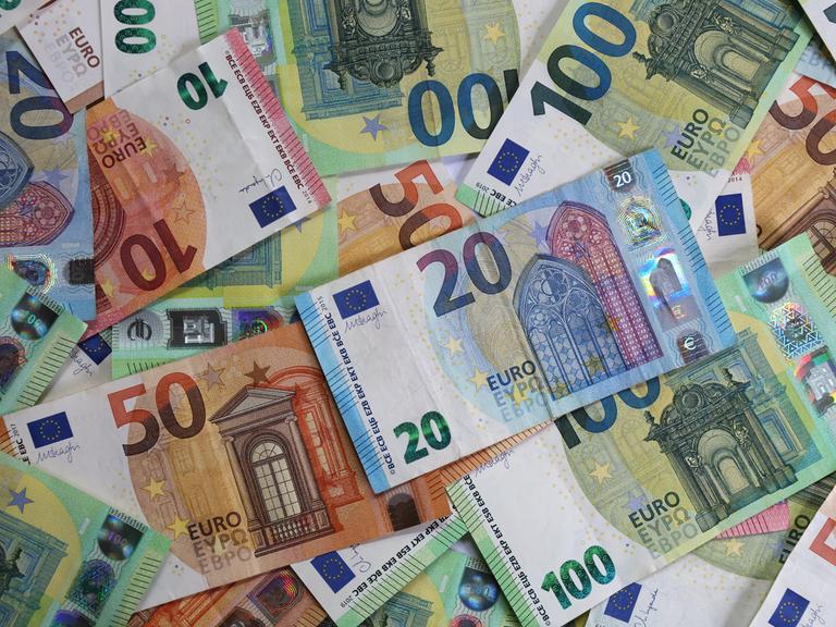 Verschiedene Euro-Banknoten liegen auf einem Tisch.