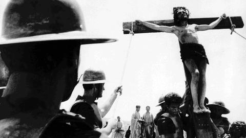 Kreuzzug mit Jesus am Kreuz - ein Schwarz-Weiß-Filmstill aus Pier Paolo Pasolinis Film "Das 1. Evangelium - Matthäus"