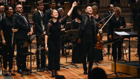 Solist und Dirigentin nehmen gemeinsam Beifall entgegen. Solist und Dirigentin nehmen gemeinsam Beifall entgegen.