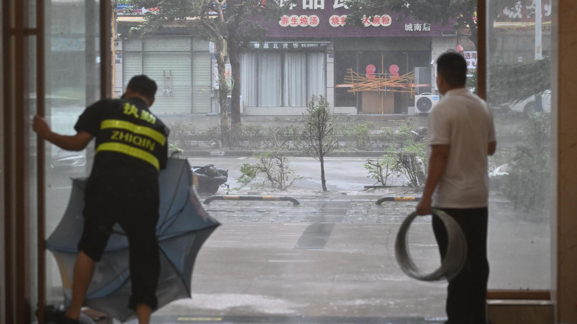 China, Yangjiang: Am Eingang eines Hotels schließen Mitarbeiter die Türen bei starken Regen nach dem Super-Taifun Ragasa.