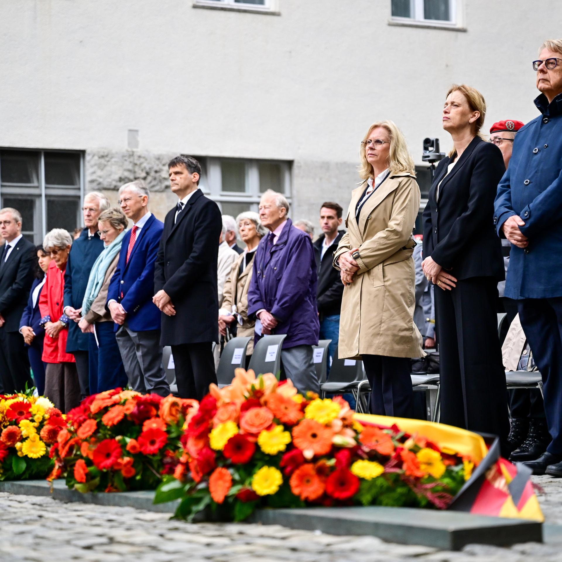 Teilnehmer, viele Minister und Ministerinnen,  stehen während einer Gedenkveranstaltung der Bundesregierung im Ehrenhof des Bendlerblocks anlässlich des Nationalen Gedenktags an den Widerstand gegen die nationalsozialistische Gewaltherrschaft. 