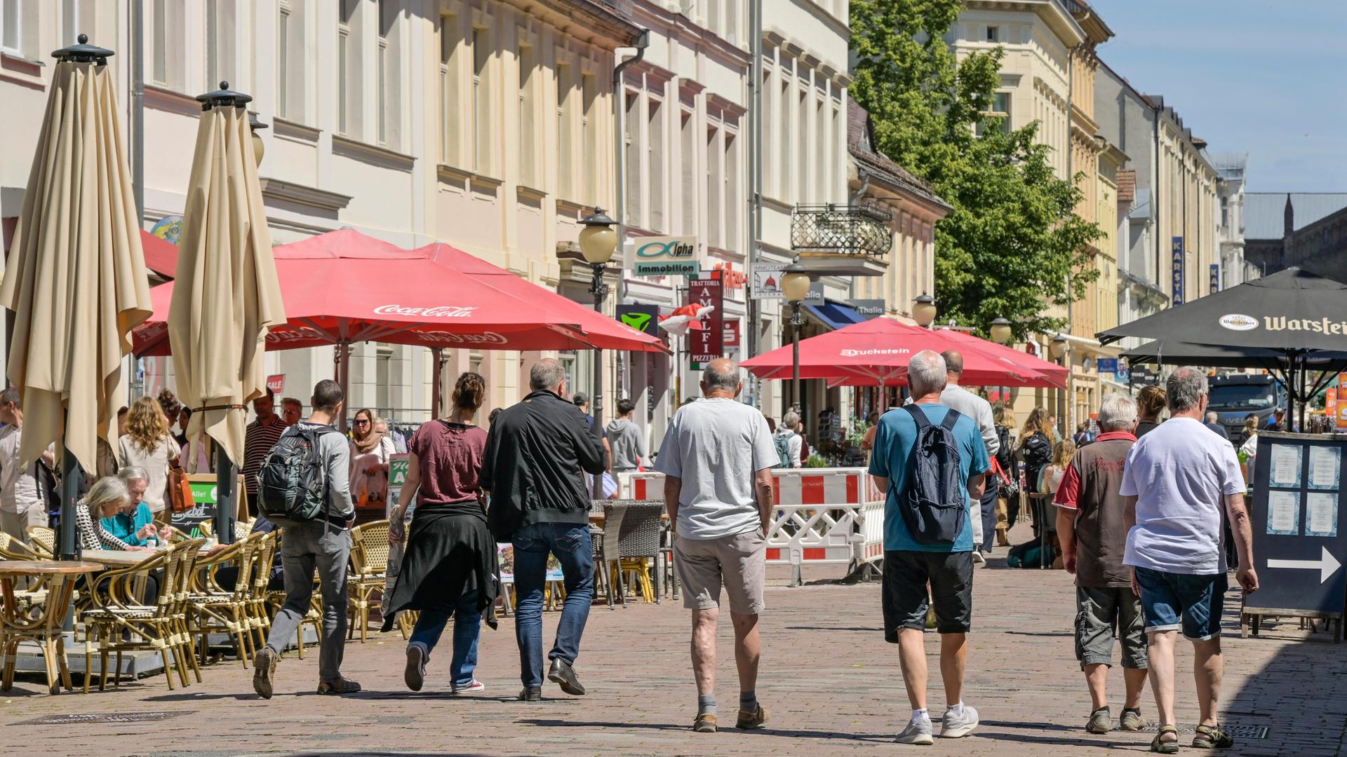 Mehrere Männer gehen durch die Fußgängerzone in der Brandenburger Straße in Potsdam