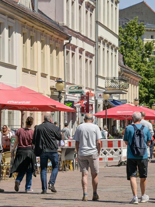 Mehrere Männer gehen durch die Fußgängerzone in der Brandenburger Straße in Potsdam Mehrere Männer gehen durch die Fußgängerzone in der Brandenburger Straße in Potsdam