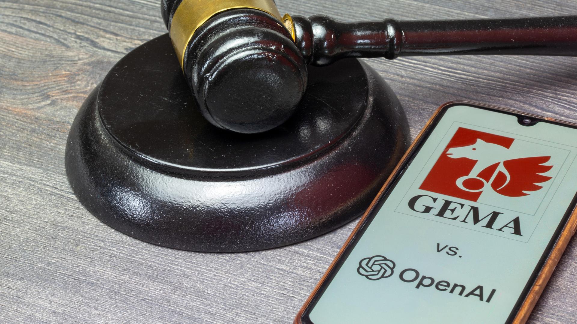 Smartphone mit GEMA- und OpenAI-Logo neben einem Richterhammer Smartphone mit GEMA- und OpenAI-Logo neben einem Richterhammer