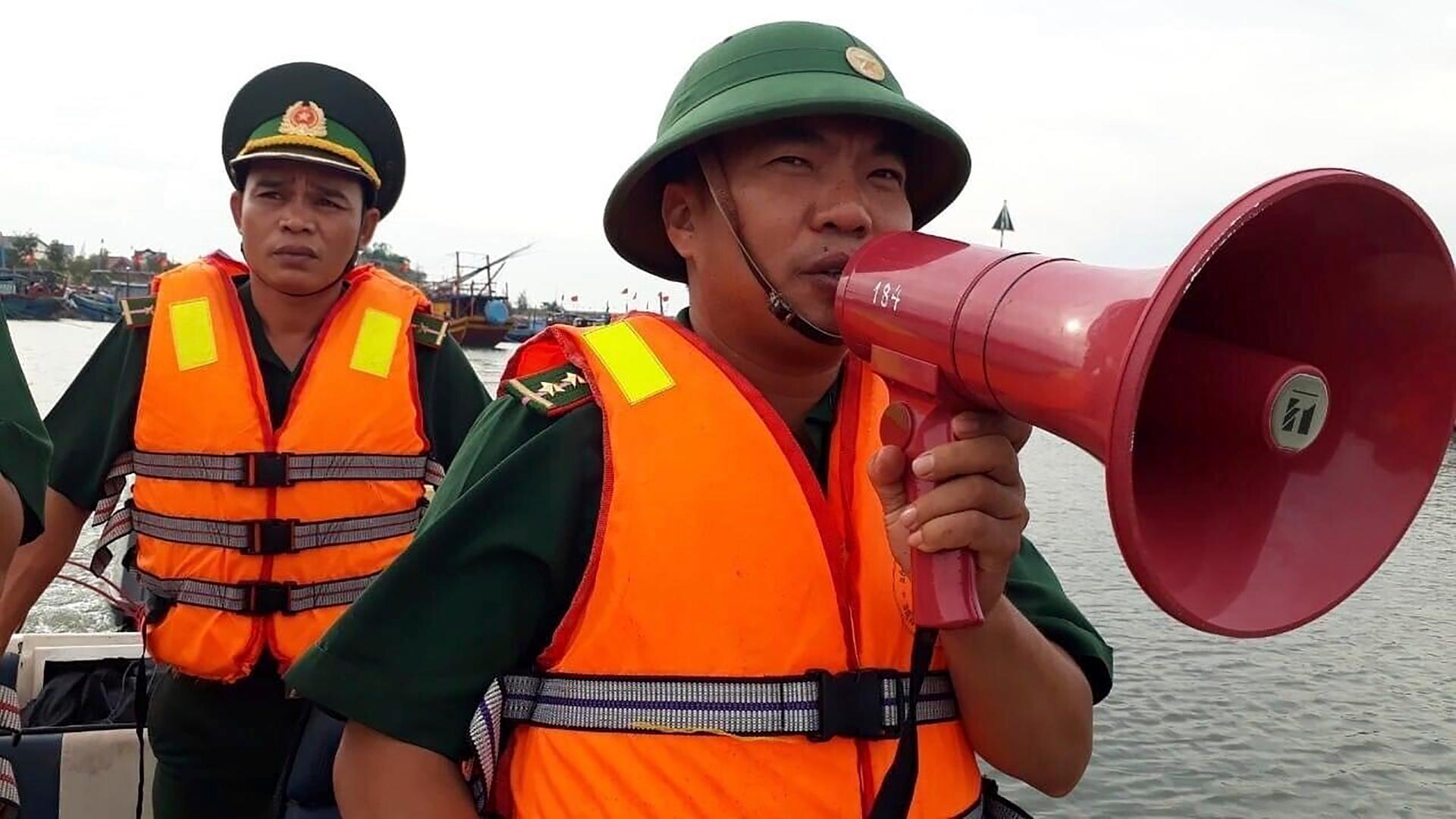 Ein Offizier der Küstenwache spricht durch ein Megafon in Vietnam. 
