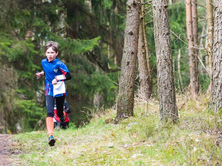 Ein Junge läuft durch den Wald