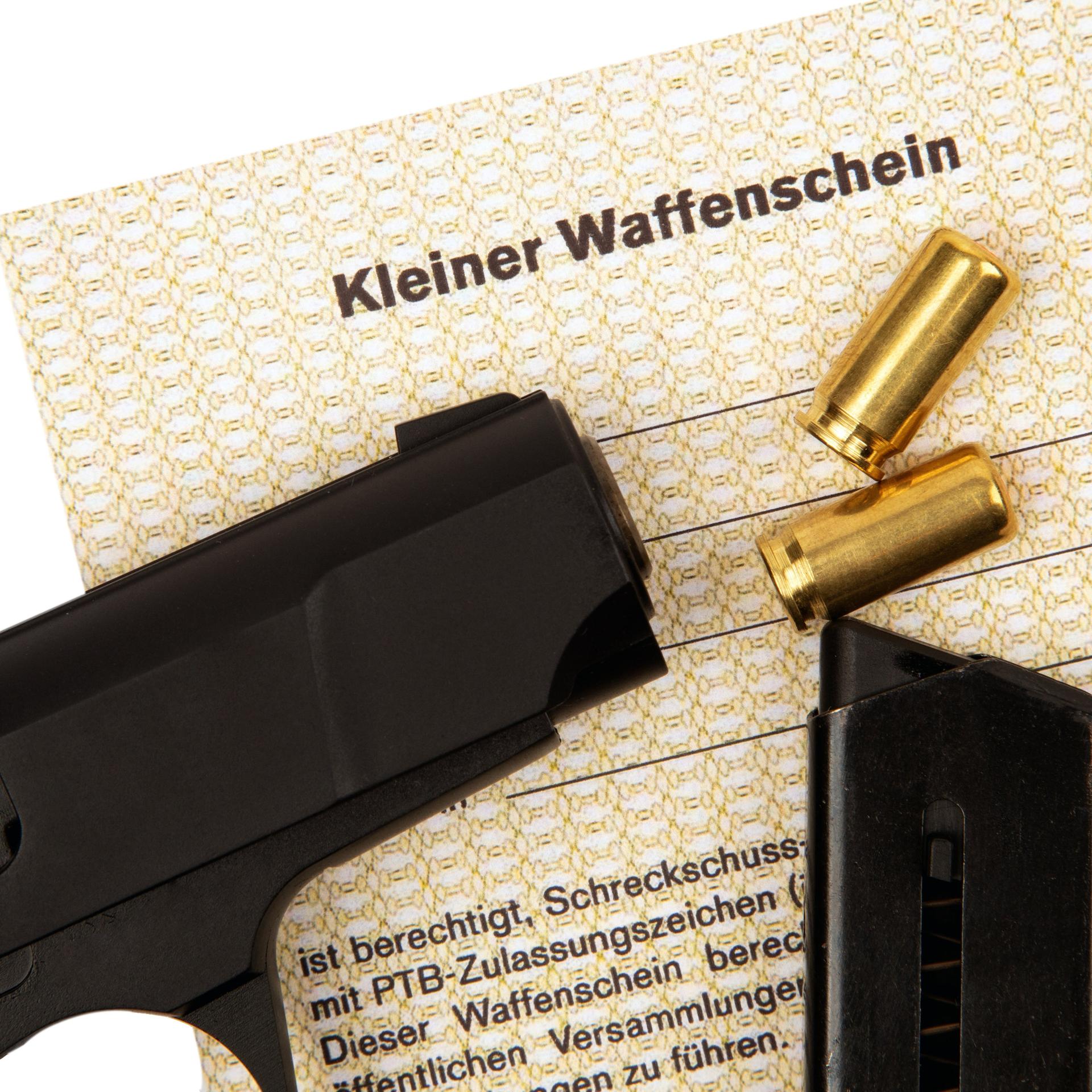 Auf einem Kleinen Waffenschein liegt eine Pistole und Munition.