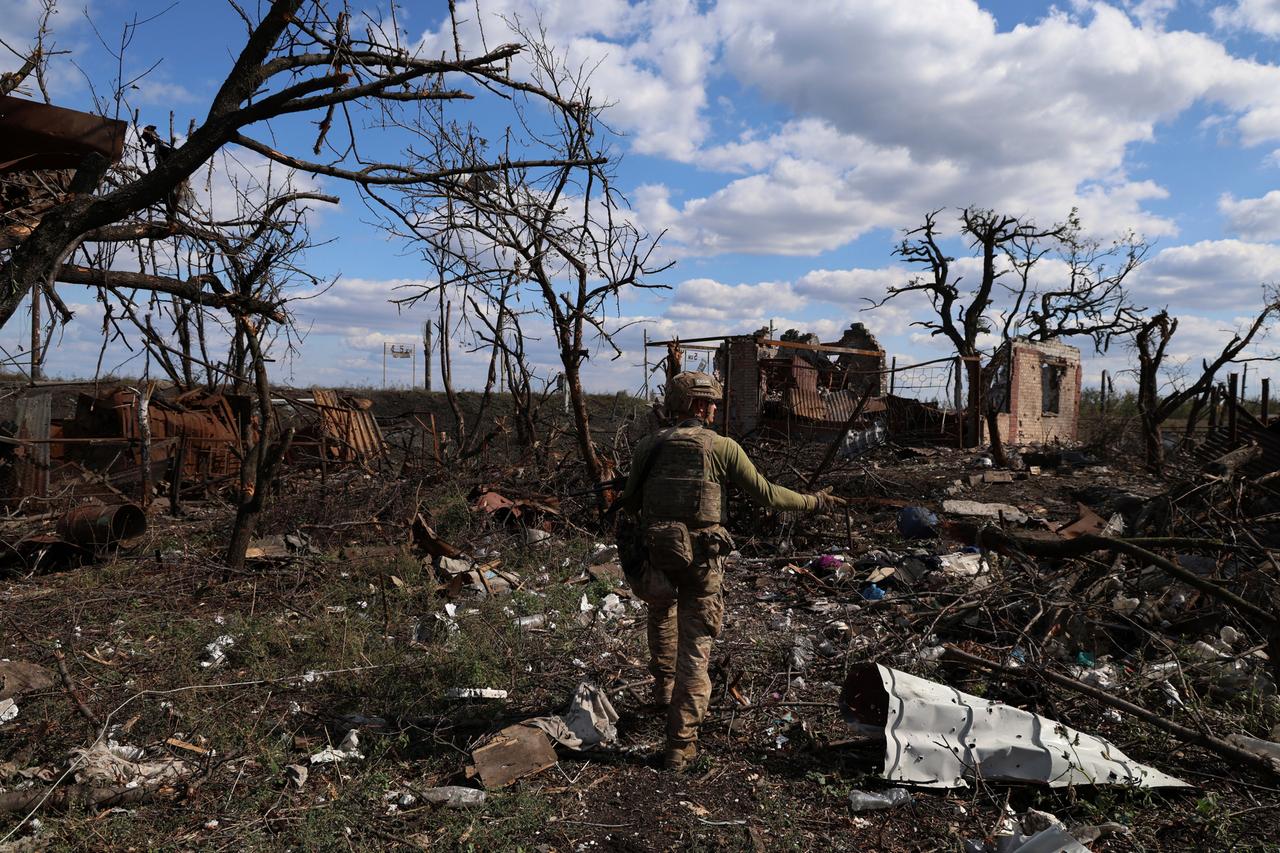Ein ukrainischer Soldat geht durch ein völlig zerbombtes Dorf an der Frontlinie