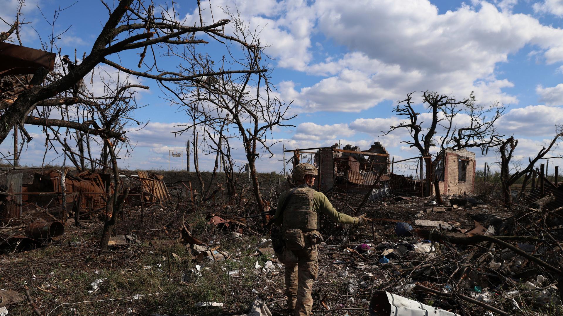 Ein ukrainischer Soldat geht durch ein völlig zerbombtes Dorf an der Frontlinie. Ein ukrainischer Soldat geht durch ein völlig zerbombtes Dorf an der Frontlinie.