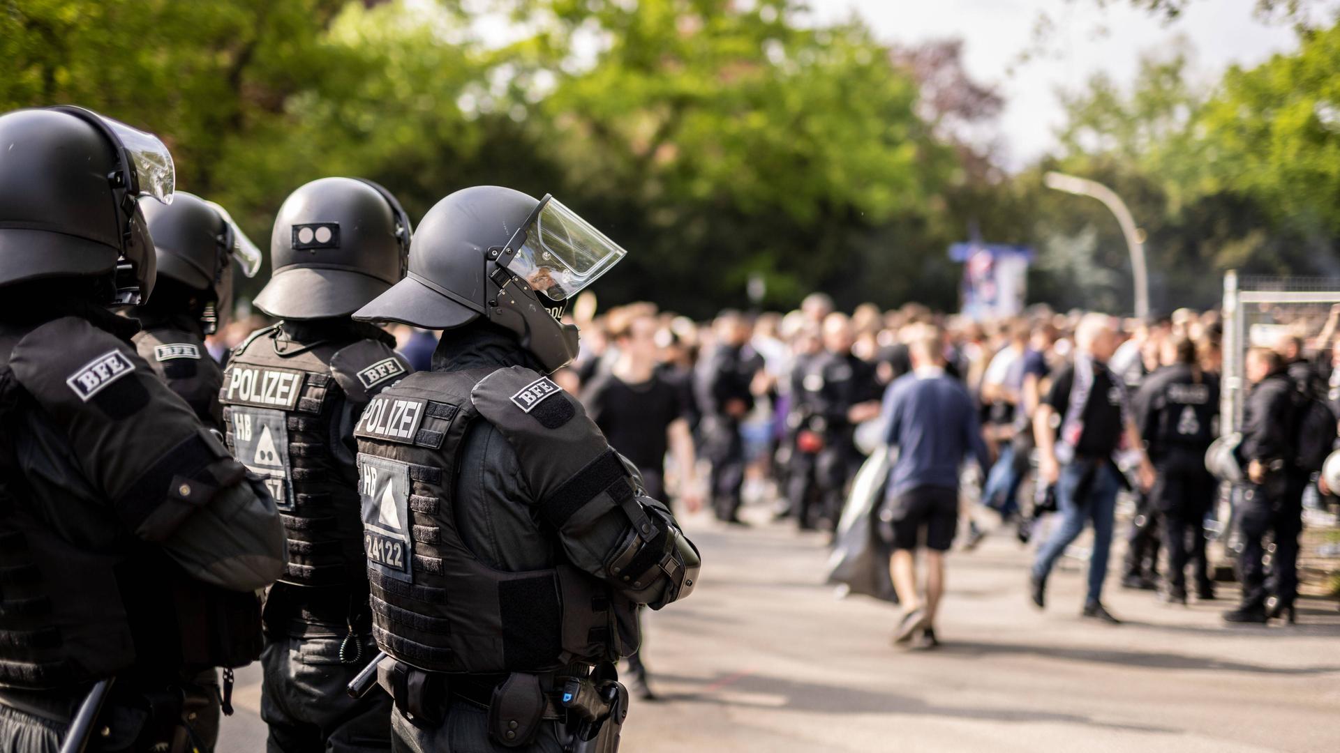 Polizeikräfte beobachten Fußballfans beim Betreten des Fußballstadions