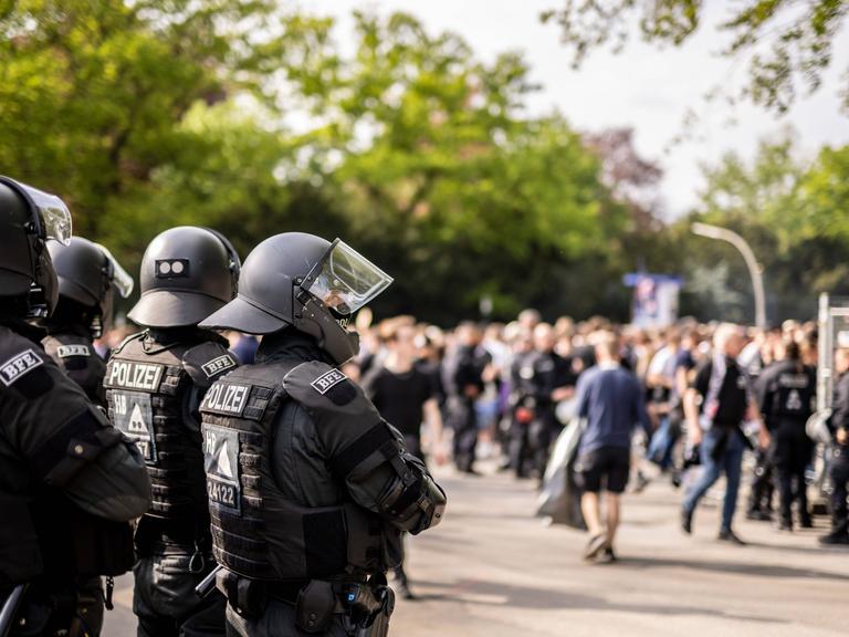 Polizeikräfte beobachten Fußballfans beim Betreten des Fußballstadions