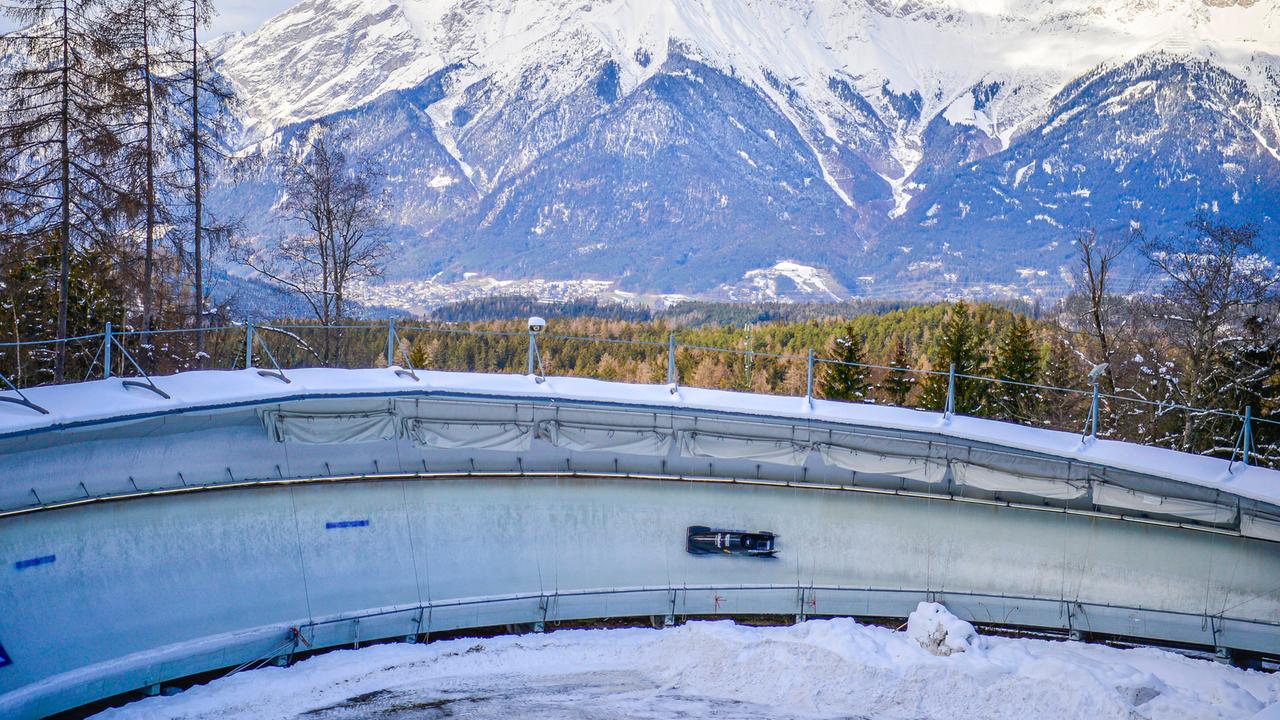 Ein Bobschlitten fährt durch einen Eiskanal.