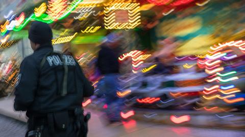 Sicherheitsmaßnahmen auf Weihnachtsmarkt in Schwerin. Ein Polizist eilt über einen Weihnachtsmarkt.