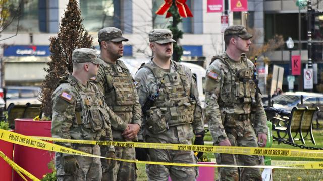 Mehrere Nationalgardisten stehen hinter einem gelben Absperrband in Washington.