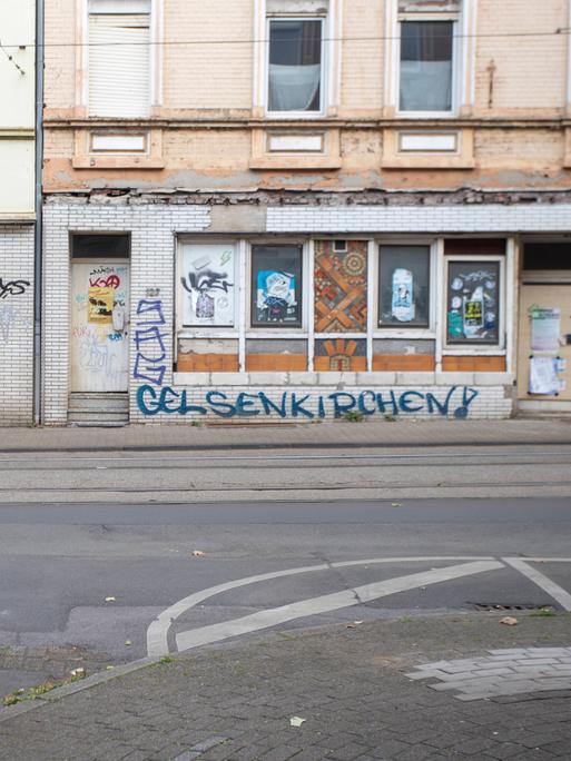 Eine Häußerfassade ist mit Bretterverschlägen versiegelt und wurde mit Grafitti verunstaltet Eine Häußerfassade ist mit Bretterverschlägen versiegelt und wurde mit Grafitti verunstaltet