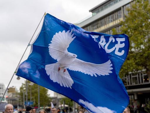 Fahne mit Friedenstaube bei der Demonstration "Die Waffen nieder" am Breitscheidplatz in Berlin