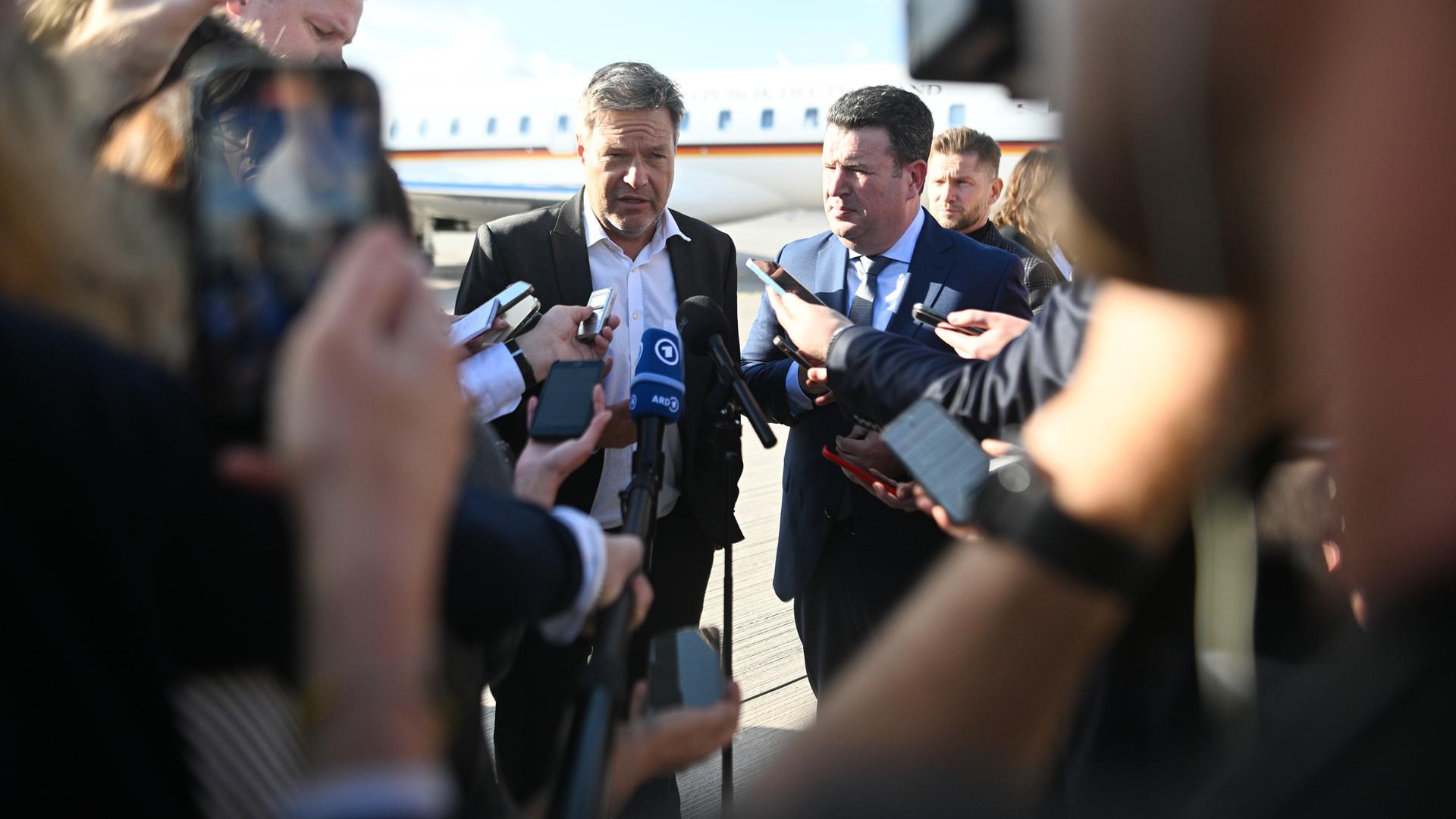 Robert Habeck und Hubertus Heil geben vor ihrer Reise zu den deutsch-indischen Regierungskonsultationen nach Neu Delhi am Flughafen Berlin Brandenburg ein Statement.