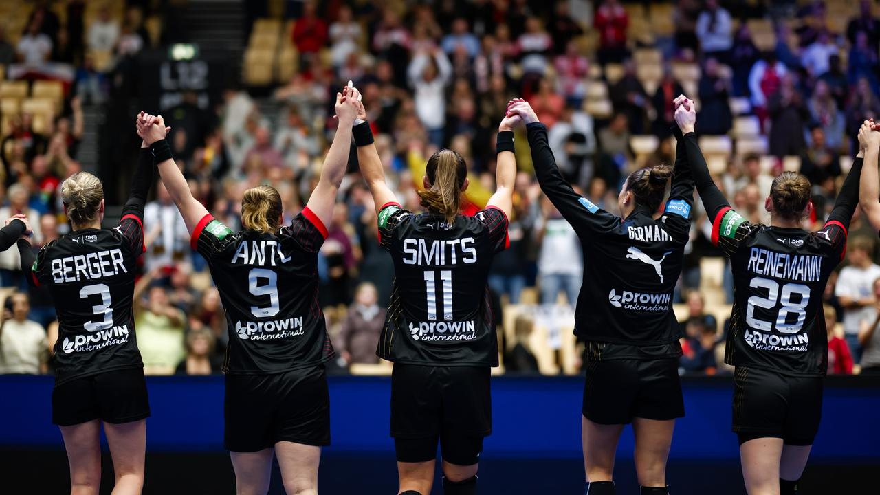 Die deutschen Handballerinnen jubeln. Sie stehen in einer Reihe und haben die Hände hochgenomen. Sie sind von hinten zu sehen.