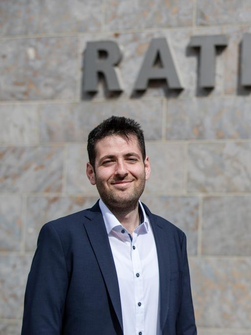 Ryyan Alshebl steht in Ostelsheim vor dem Rathaus und posiert für ein Pressefoto.