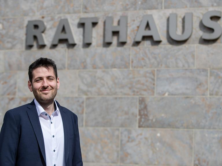 Ryyan Alshebl steht in Ostelsheim vor dem Rathaus und posiert für ein Pressefoto.