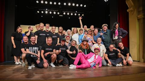 Das Ensemble des Visionäre e.V. stellen sich zu einem Gruppenbild auf die Bühne.