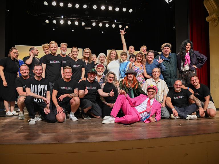 Das Ensemble des Visionäre e.V. stellen sich zu einem Gruppenbild auf die Bühne.