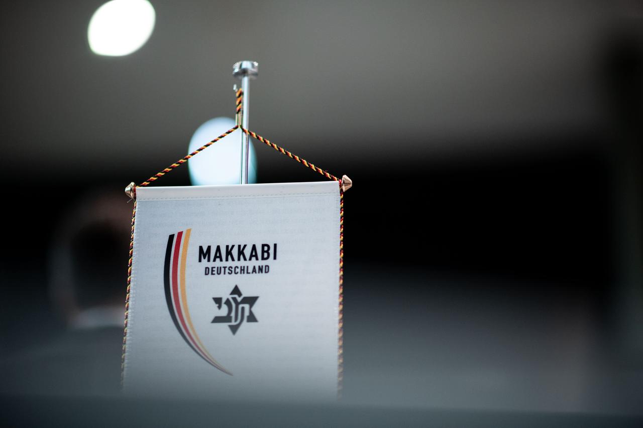 Ein Wimpel mit dem Logo der Makkabi-Bewegung steht auf einem Tisch.