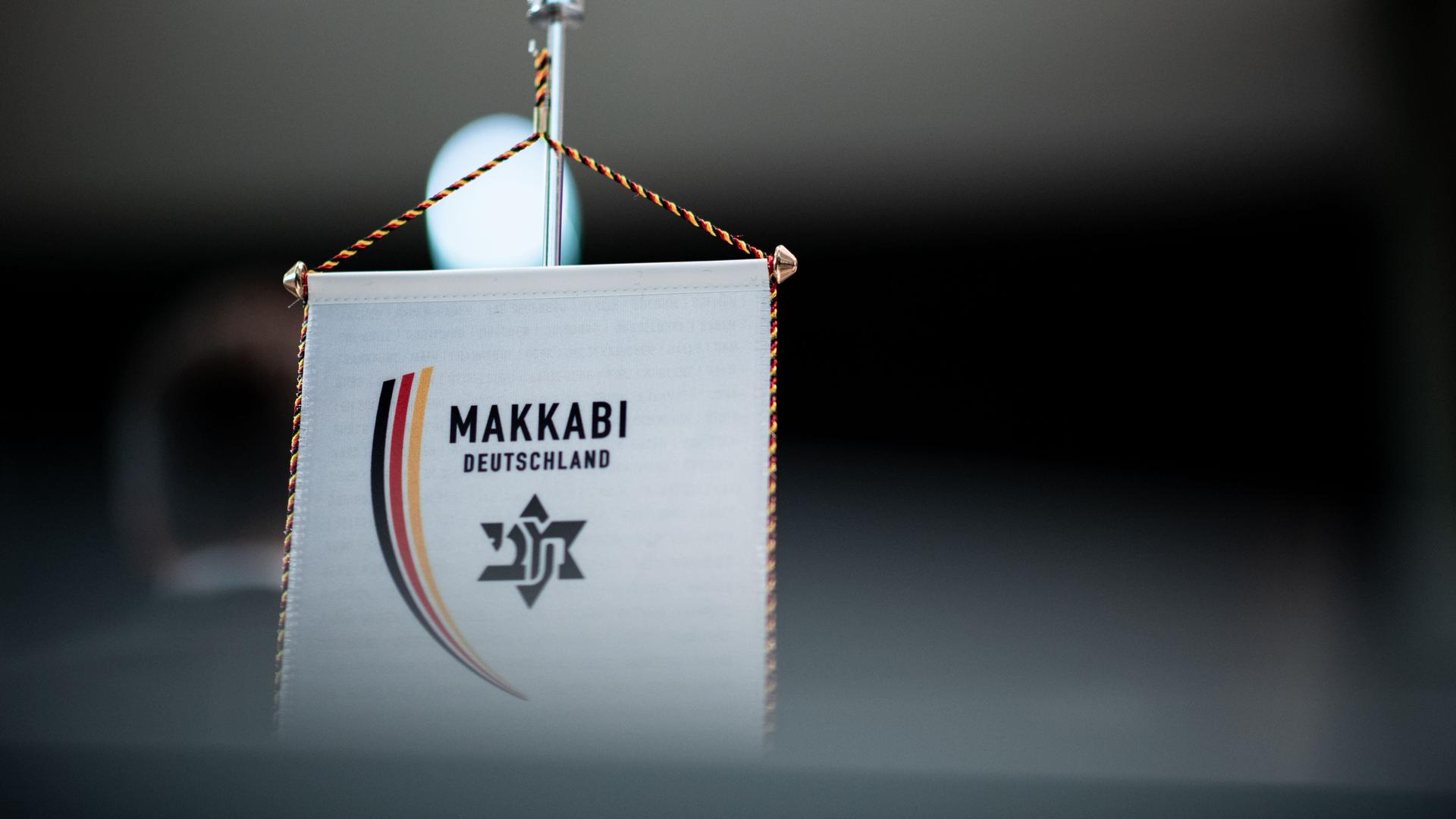 Ein Wimpel mit dem Logo der jüdischen Sportbewegung Makkabi steht auf einem Tisch. Ein Wimpel mit dem Logo der jüdischen Sportbewegung Makkabi steht auf einem Tisch.