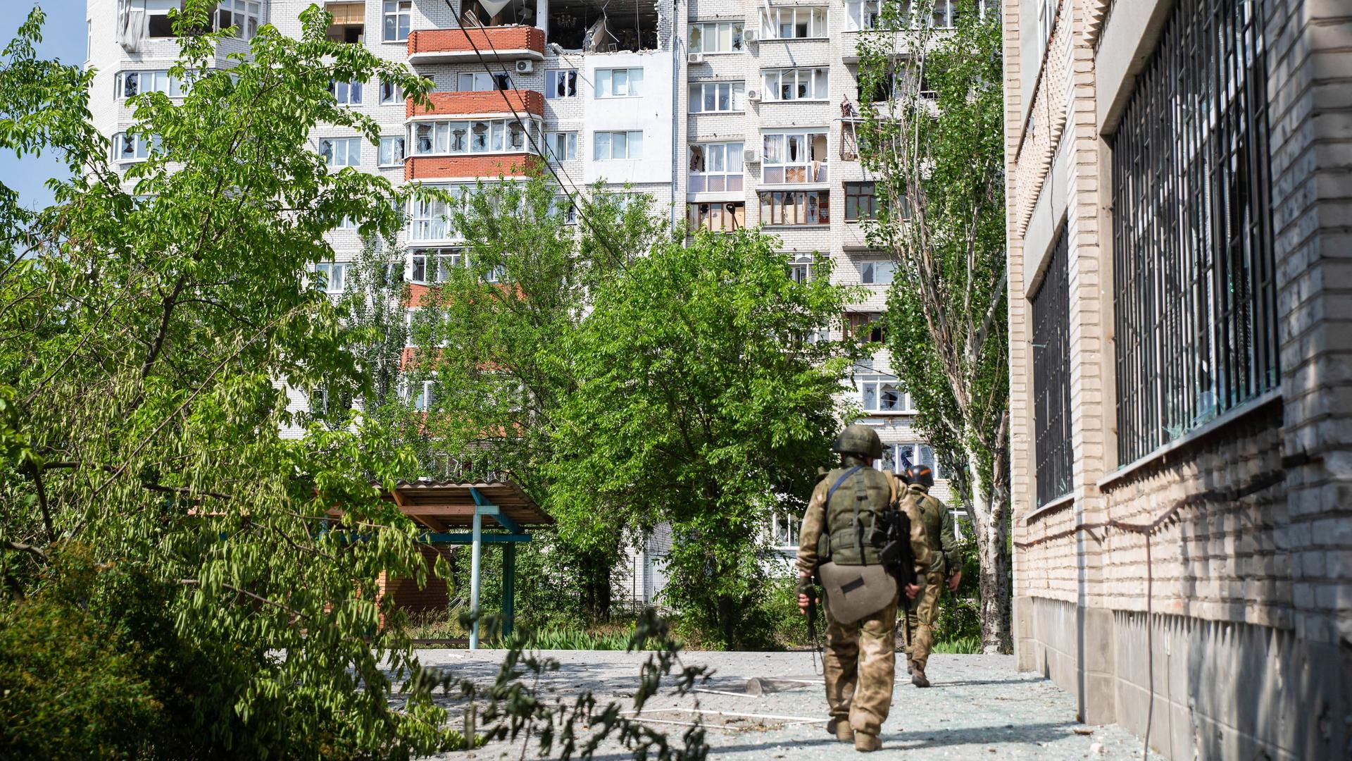 Ein russischer Kämpfer geht durch die ukrainische Stadt Sjewjerodonezk.