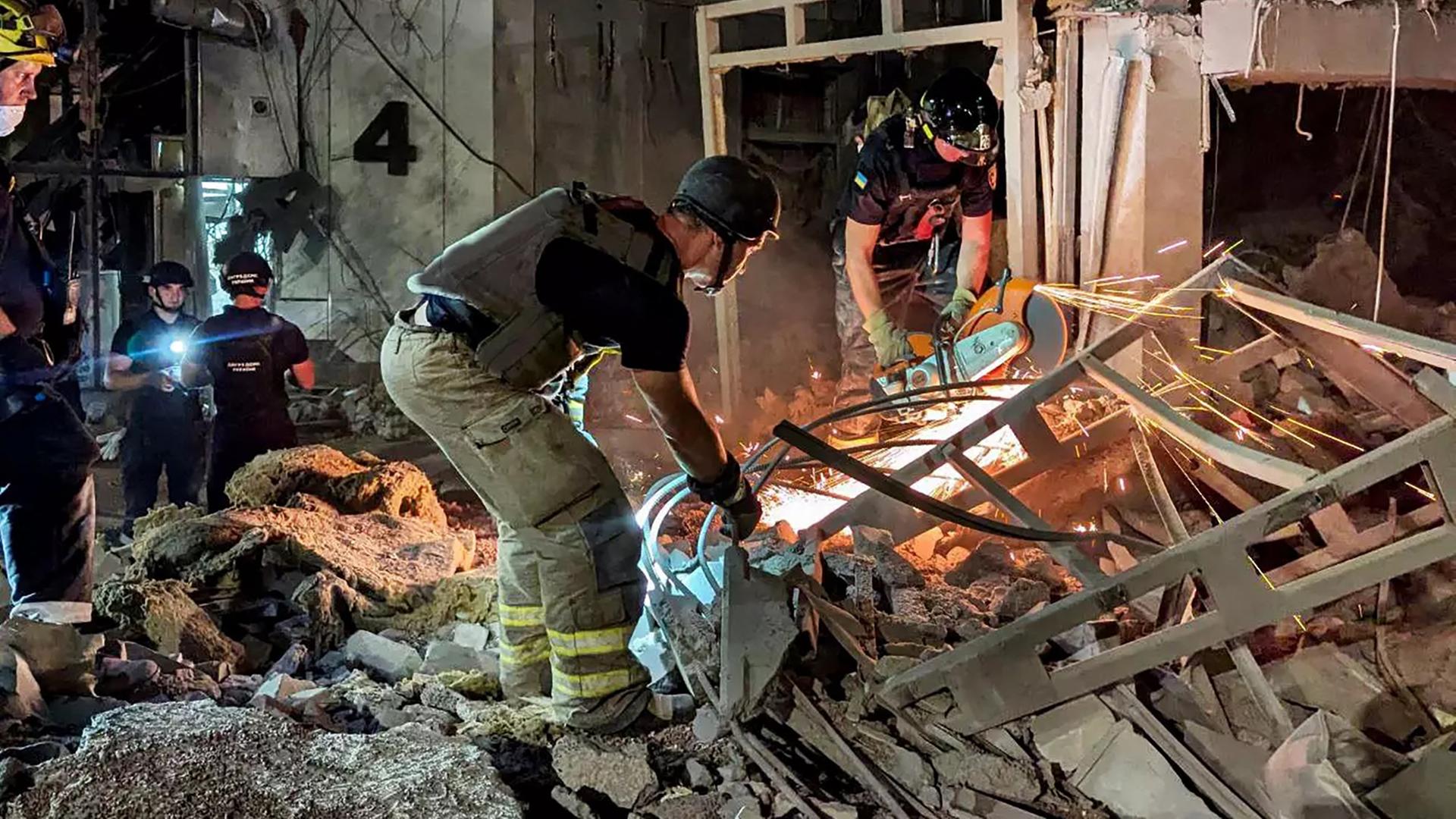 Feuerwehr-Männer in einem zerstörtes Haus in dem Land Ukraine. Das Haus wurde durch einen russischen Raketen-Angriff zerstört. 