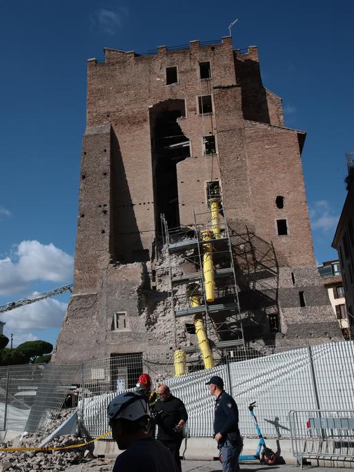 Der mittelalterliche Torre Dei Conti mit zum Teil eingestürzter Seitenwand. Davor stehen Geräte und Helfer der Feuerwehr.