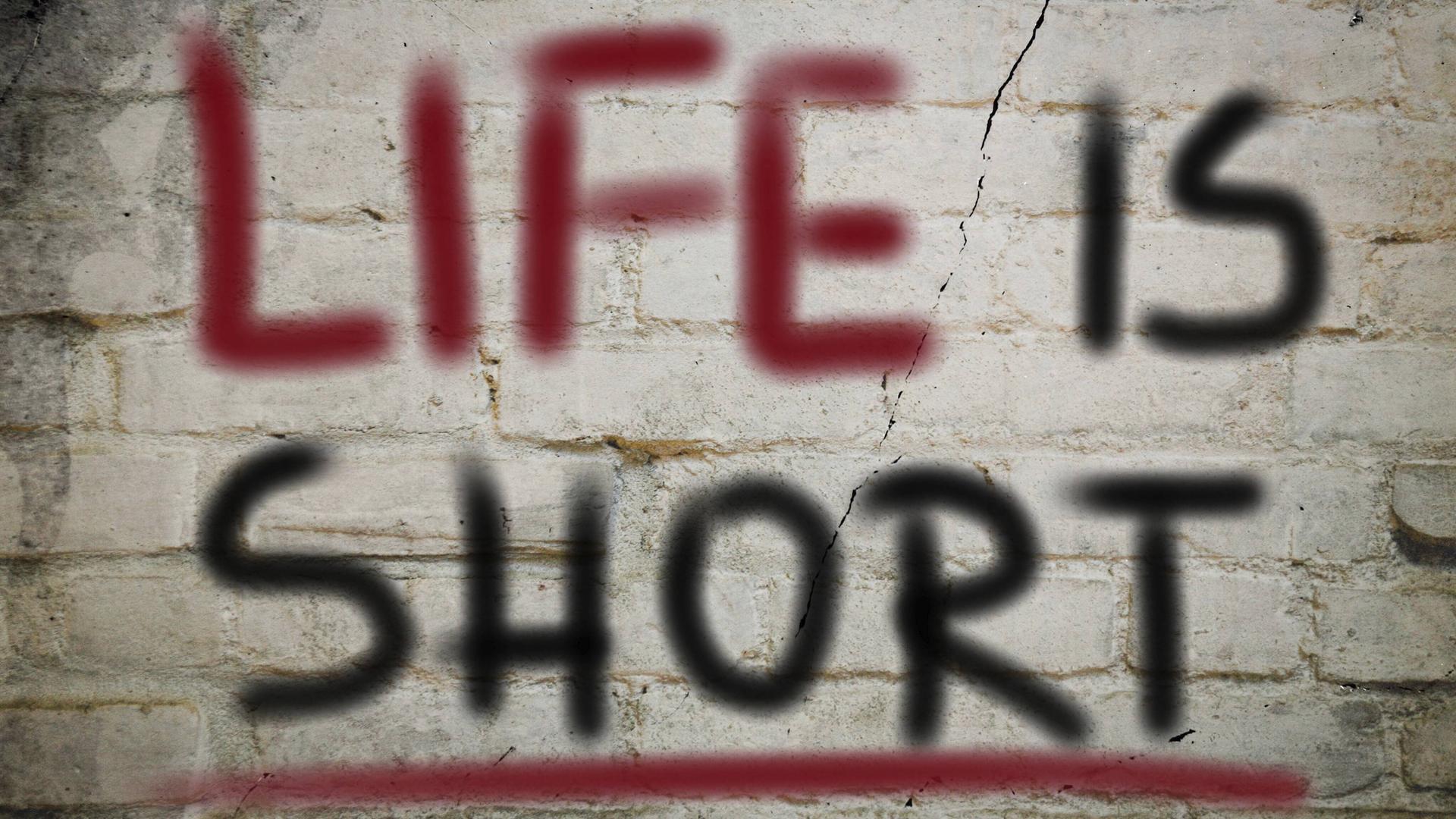 Auf einer Wand steht "Life is short": Das Leben ist kurz.