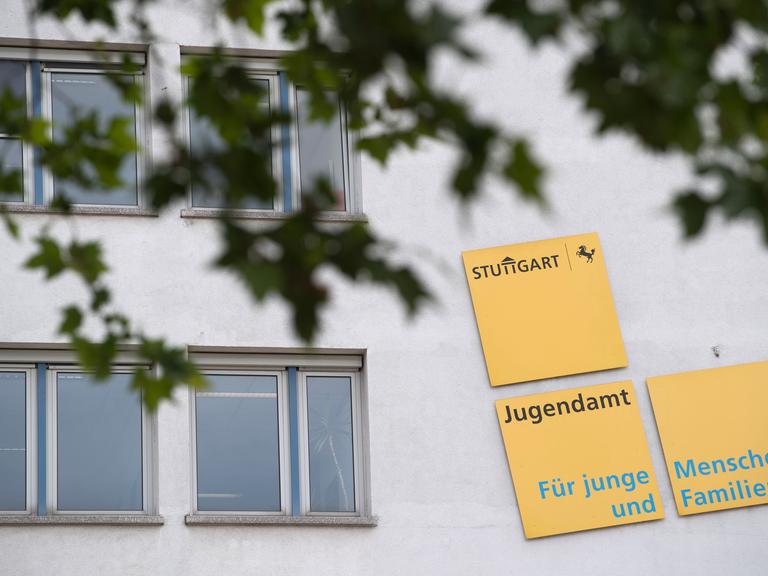 Auf einer Fassade weisen Schilder auf das Jugendamt Stuttgart hin.