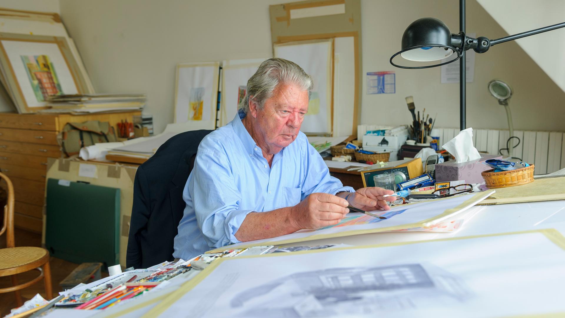 Jean-Jacques Sempé sitzt an einem Schreibtisch und zeichnet