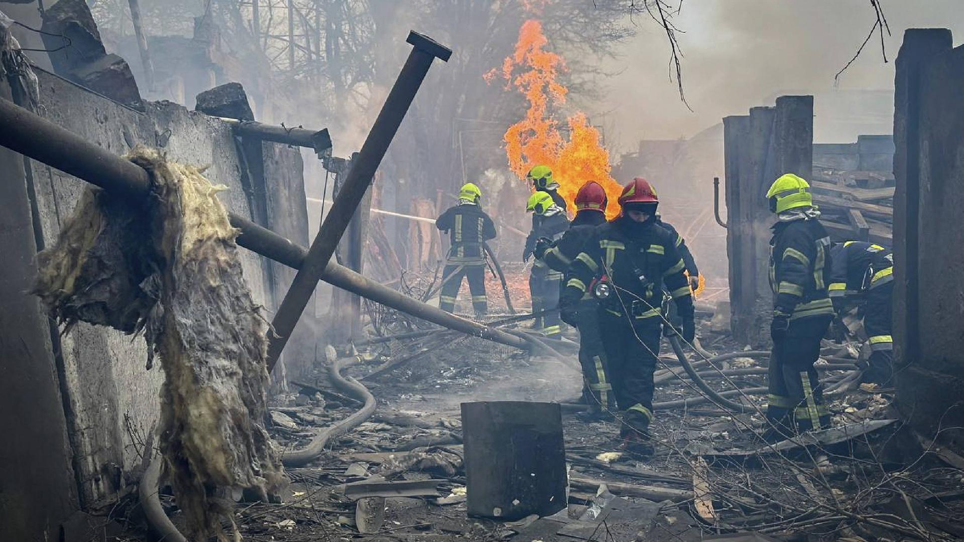 Feuerwehrmänner versuchen in einem völlig zerstörten Haus einen Brand zu löschen.
