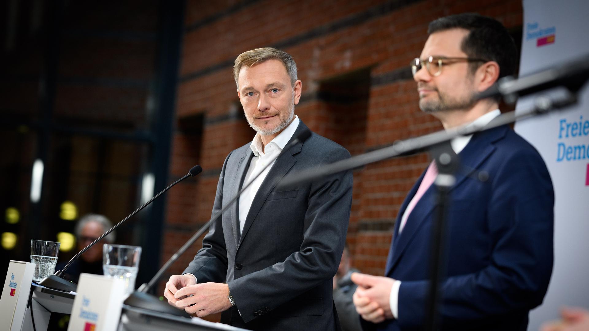 Lindner und Buschmann stehen während einer Pressekonferenz nebeneinander hinter jeweiligen Rednerpulten.